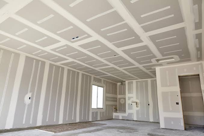 Fully taped drywall ceiling and walls in a large room ready for finishing